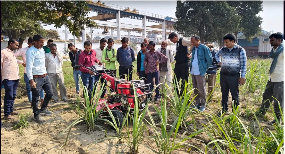 A group of farmers sees a power tiller how it works in the field.